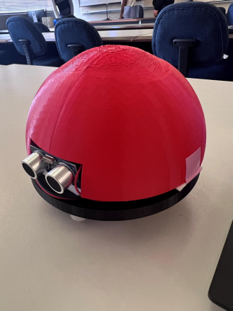 The assembled UV-C sterilization robot: a red 3D-printed dome on a black circular base, with two ultrasonic sensors facing forward