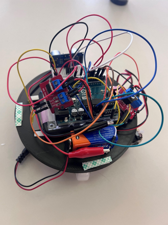 Interior of the robot showing the Arduino board, motor driver modules, lithium battery, and wiring on the circular chassis